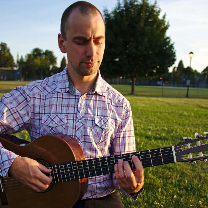 Brett playing guitar in Hampstead park