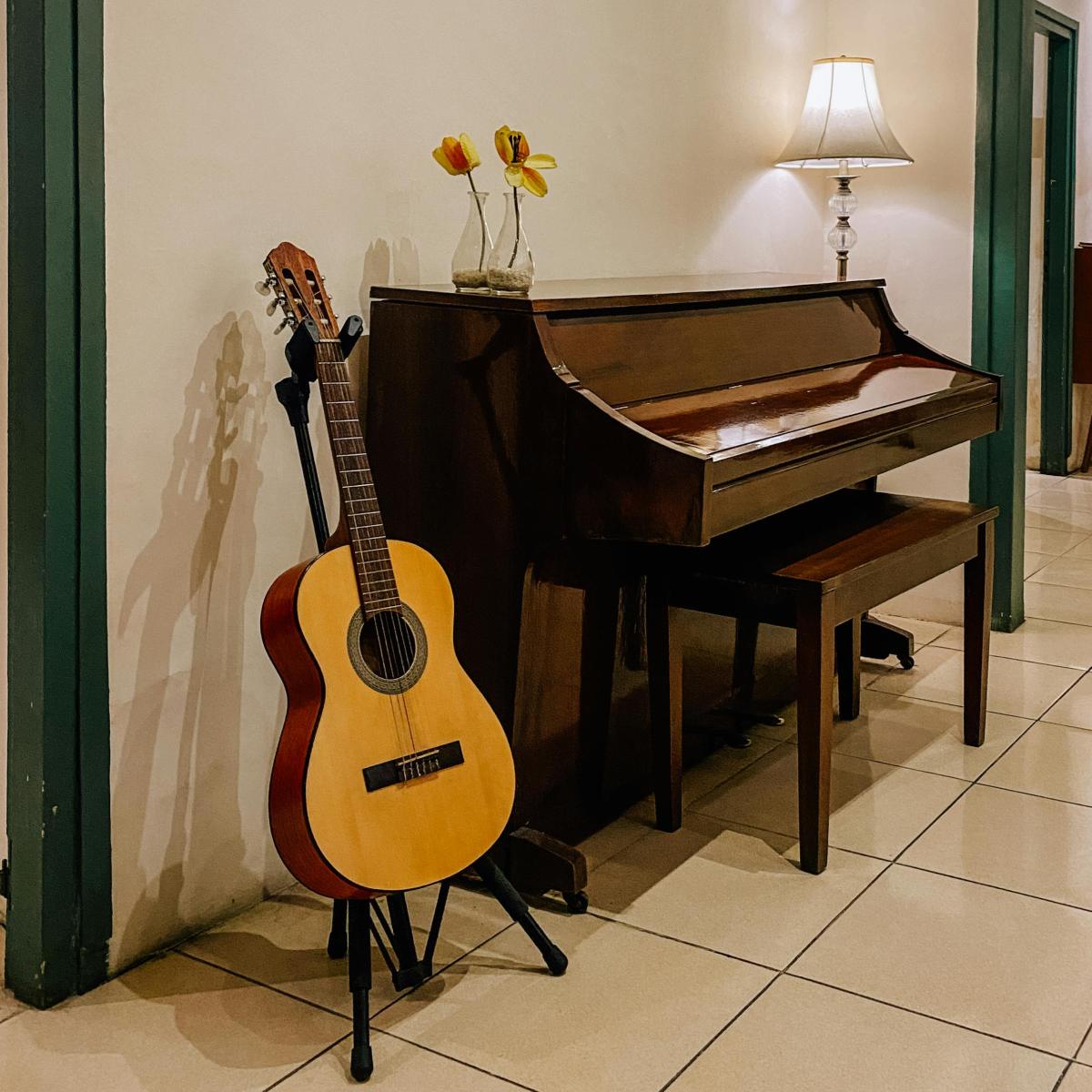 An image of a classical guitar next to a piano