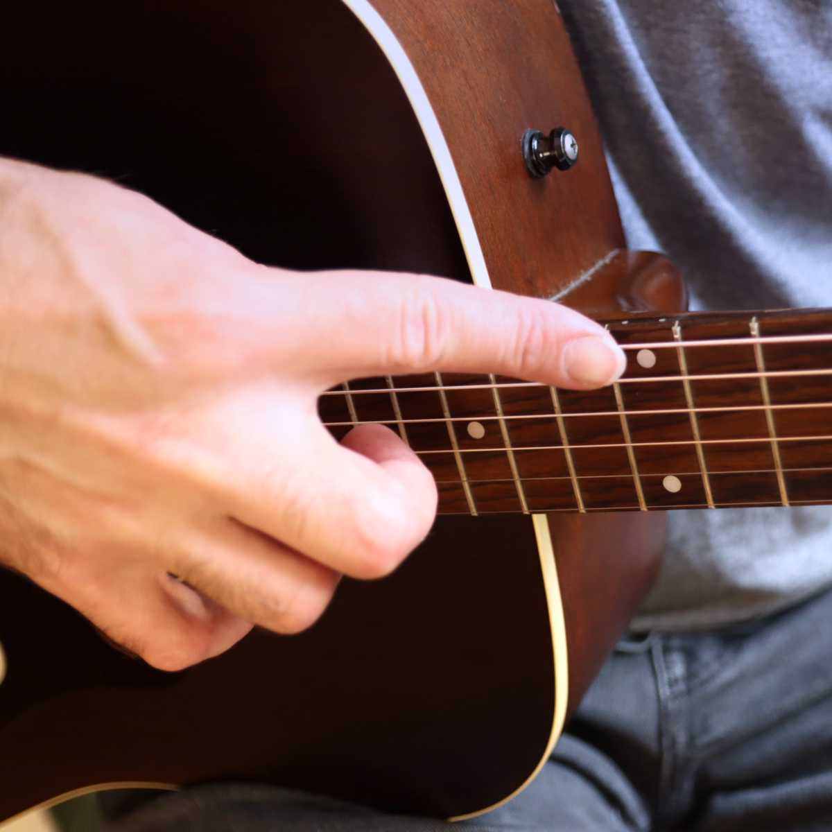 An index finger touching the node on the guitar string, exactly like for cascading harmonics